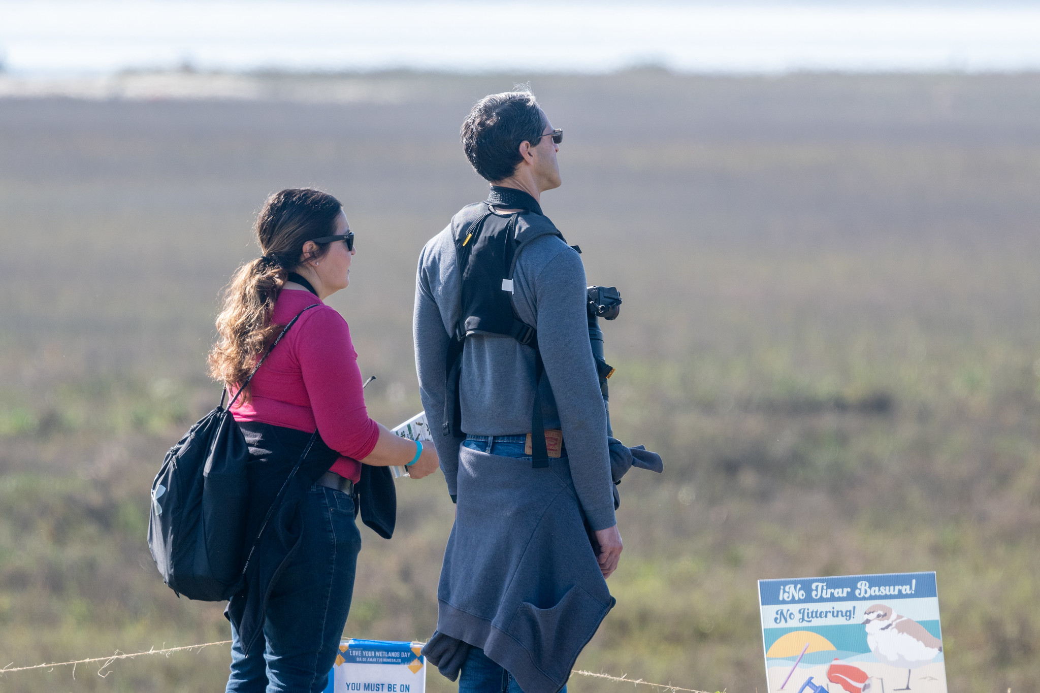 Visitors with cameras and binoculars enjoy the view.