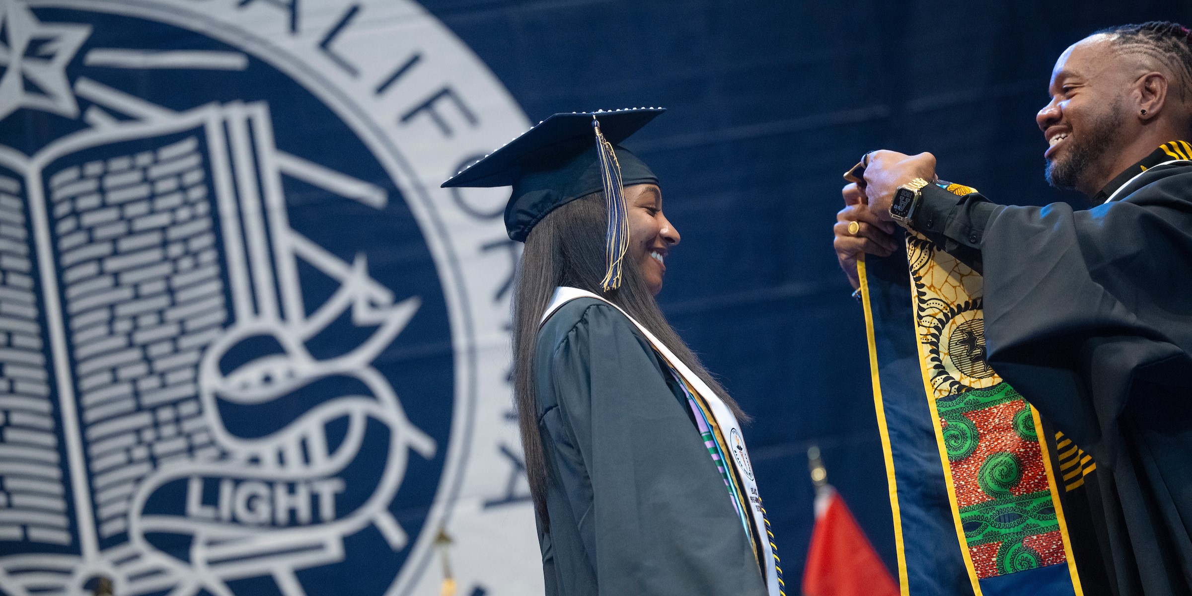 The BRC director about to drape a decorative stole over a graduating student