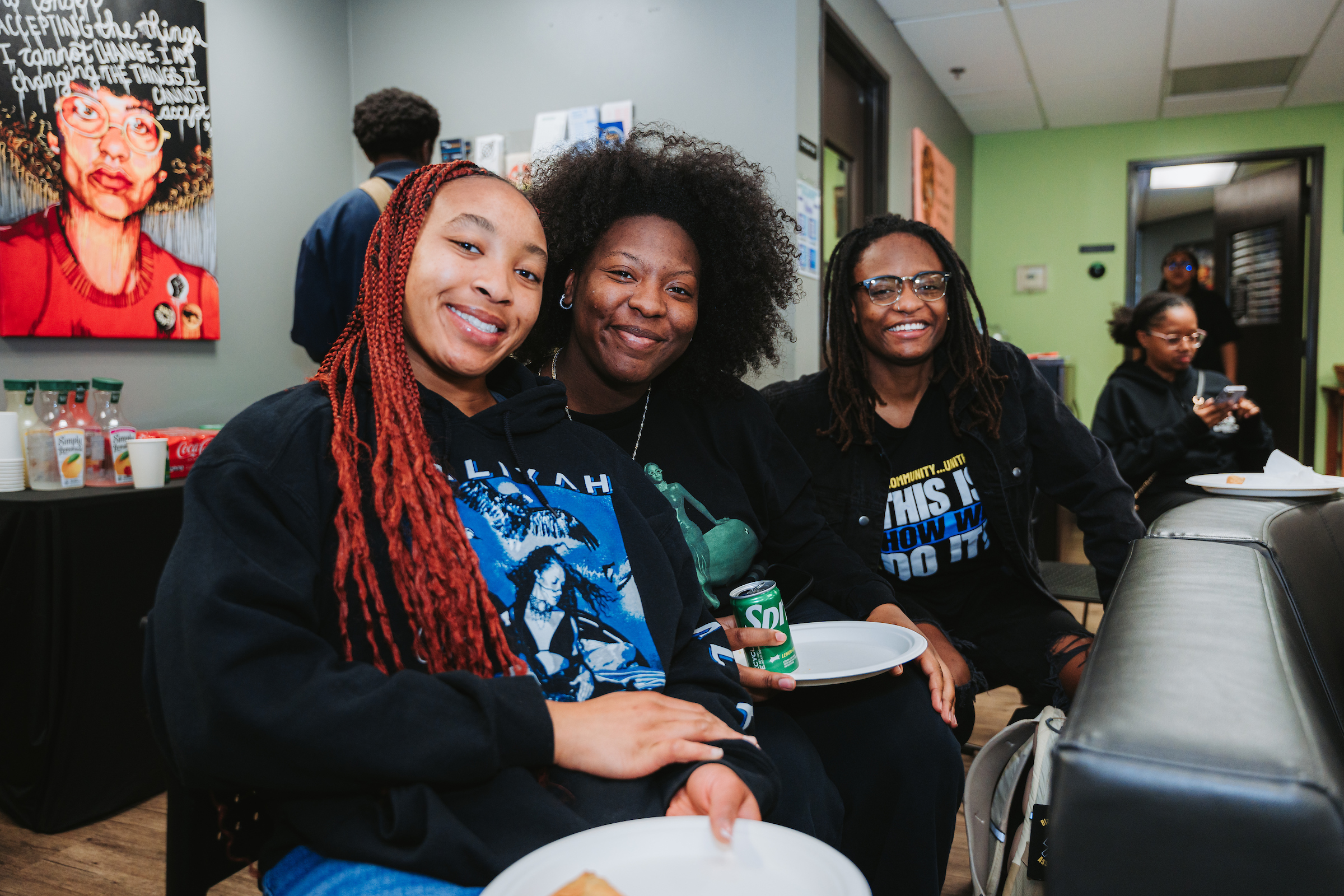 Three people smile at the camera