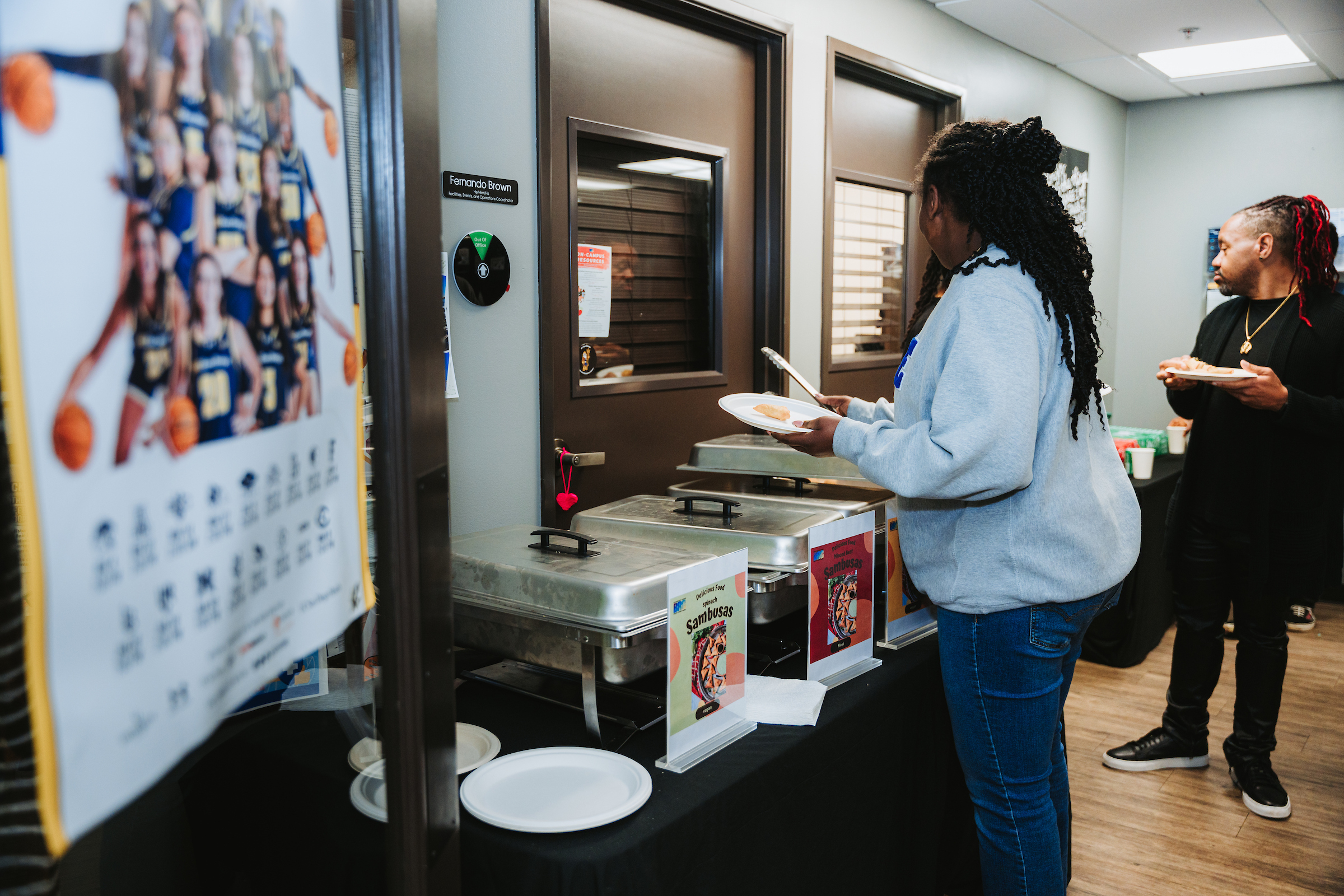 A person takes food from buffet trays