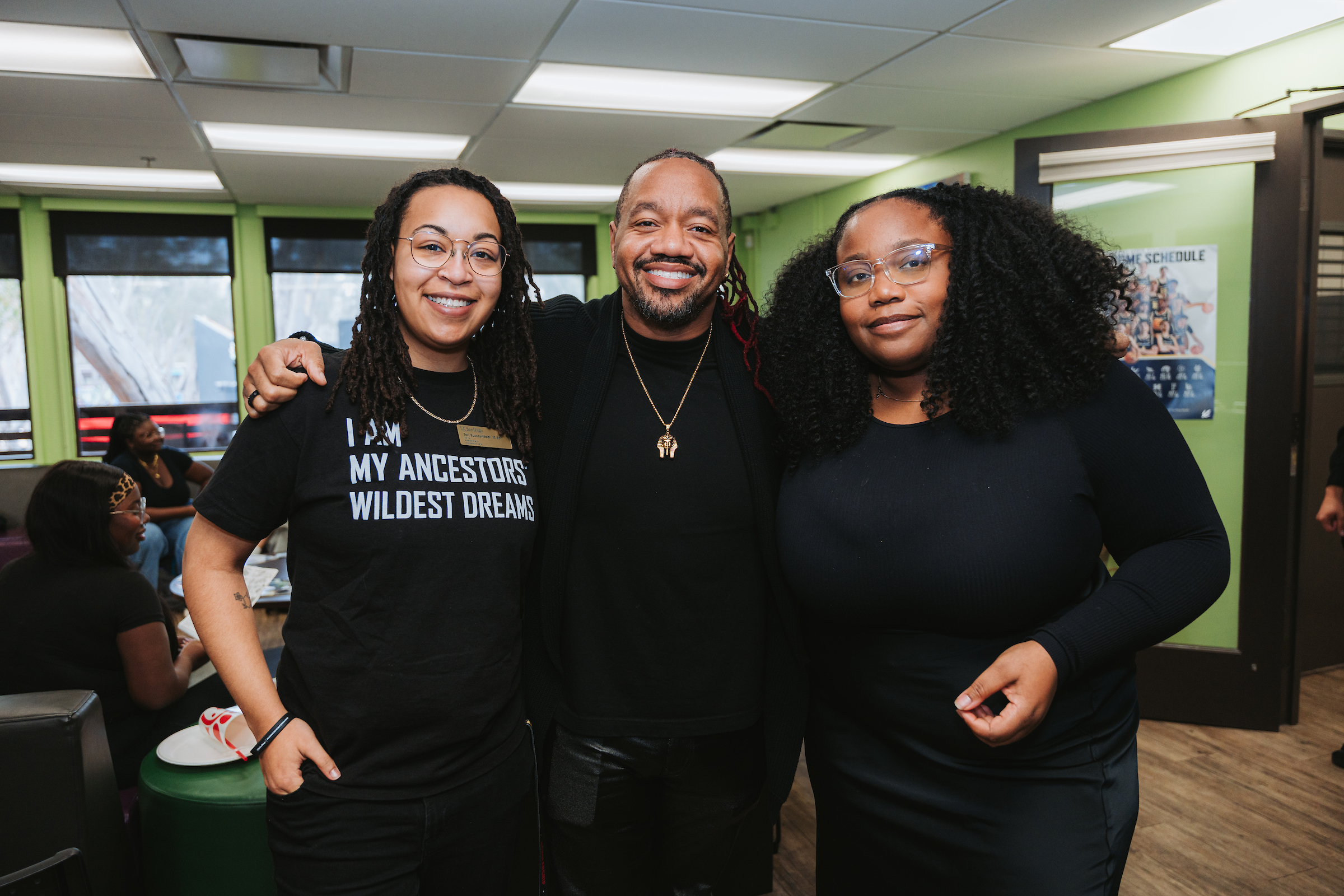 Three people smile at the camera