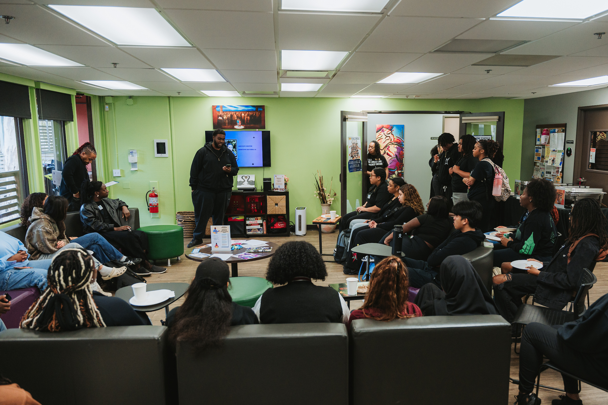 A wide angle shot with a group of people sitting on a large couch