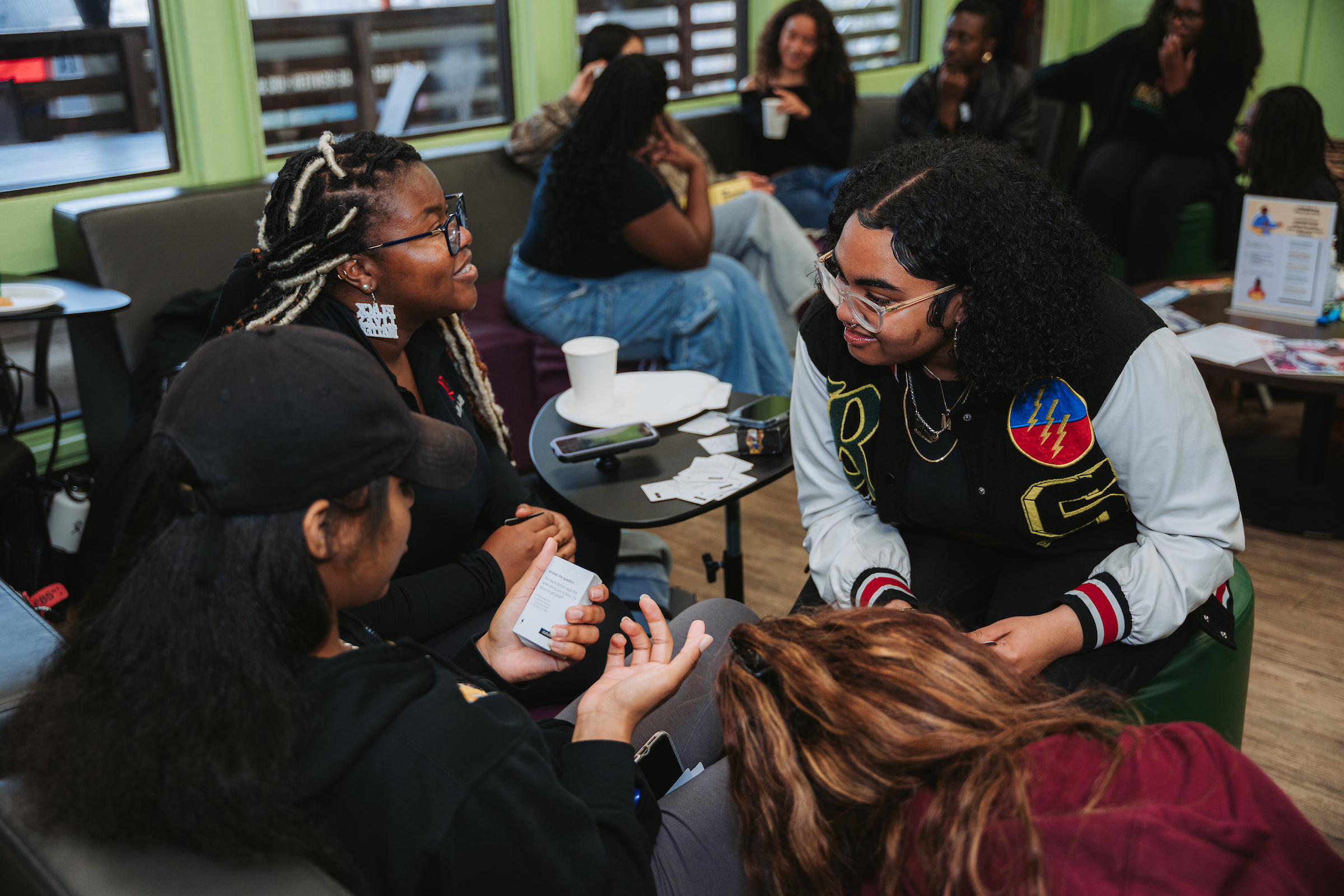 Three people laugh together while playing a game