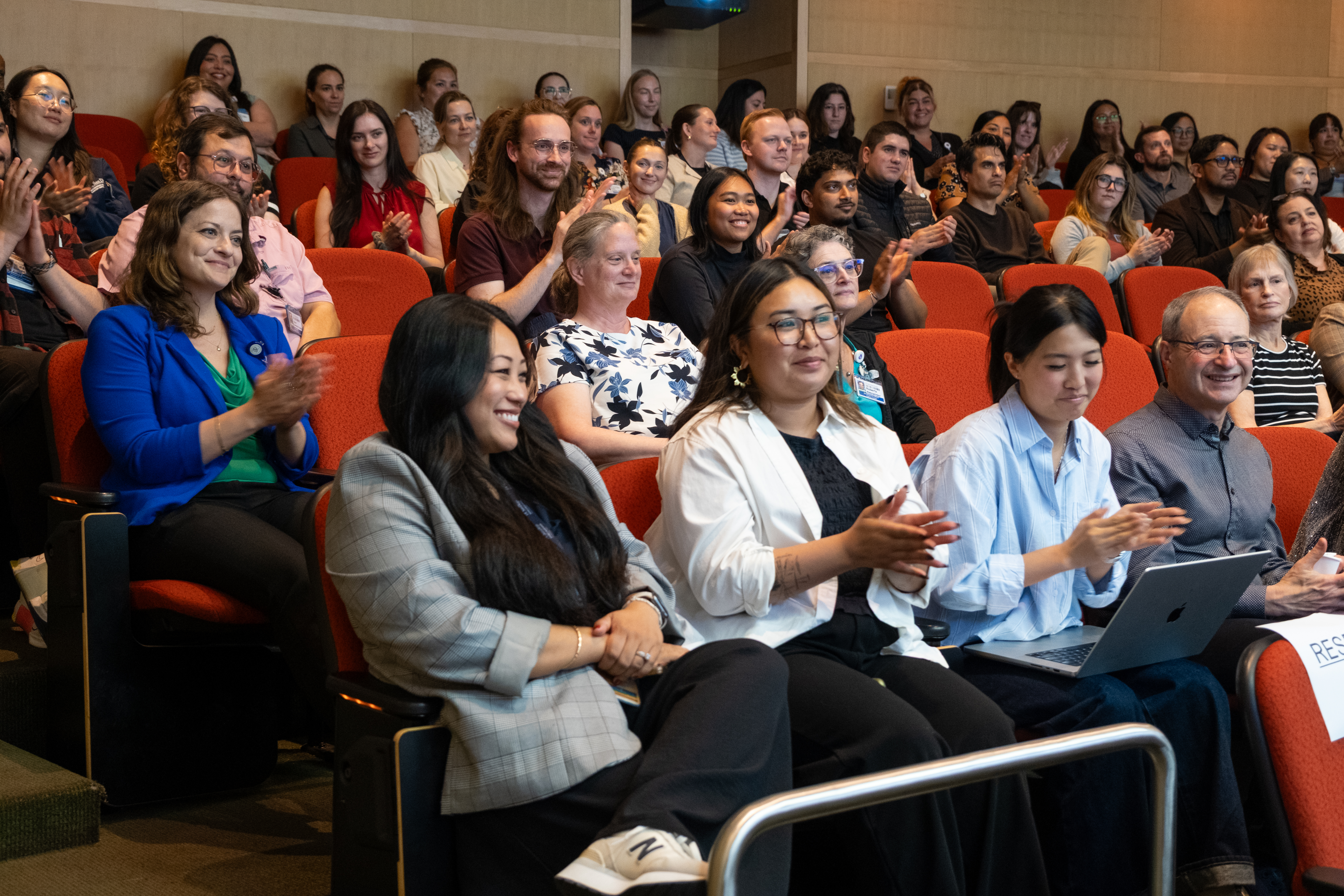 Clinical trials staff in the audience clapping