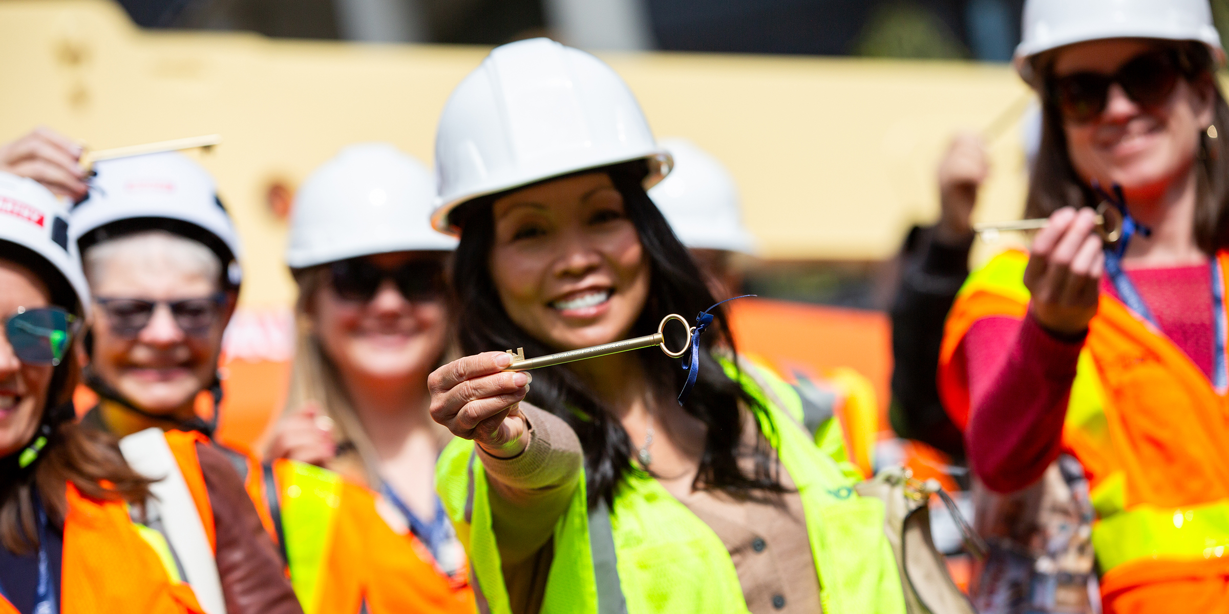 Woman with hard hat holding gold key
