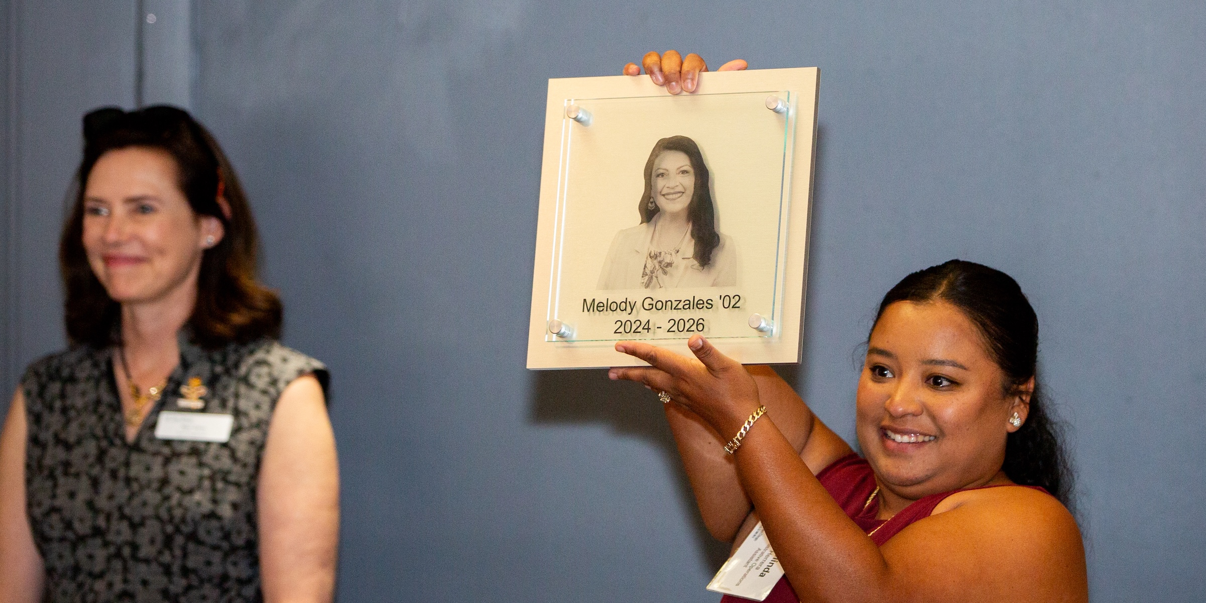 A woman holding a plaque of Melody Gonzales