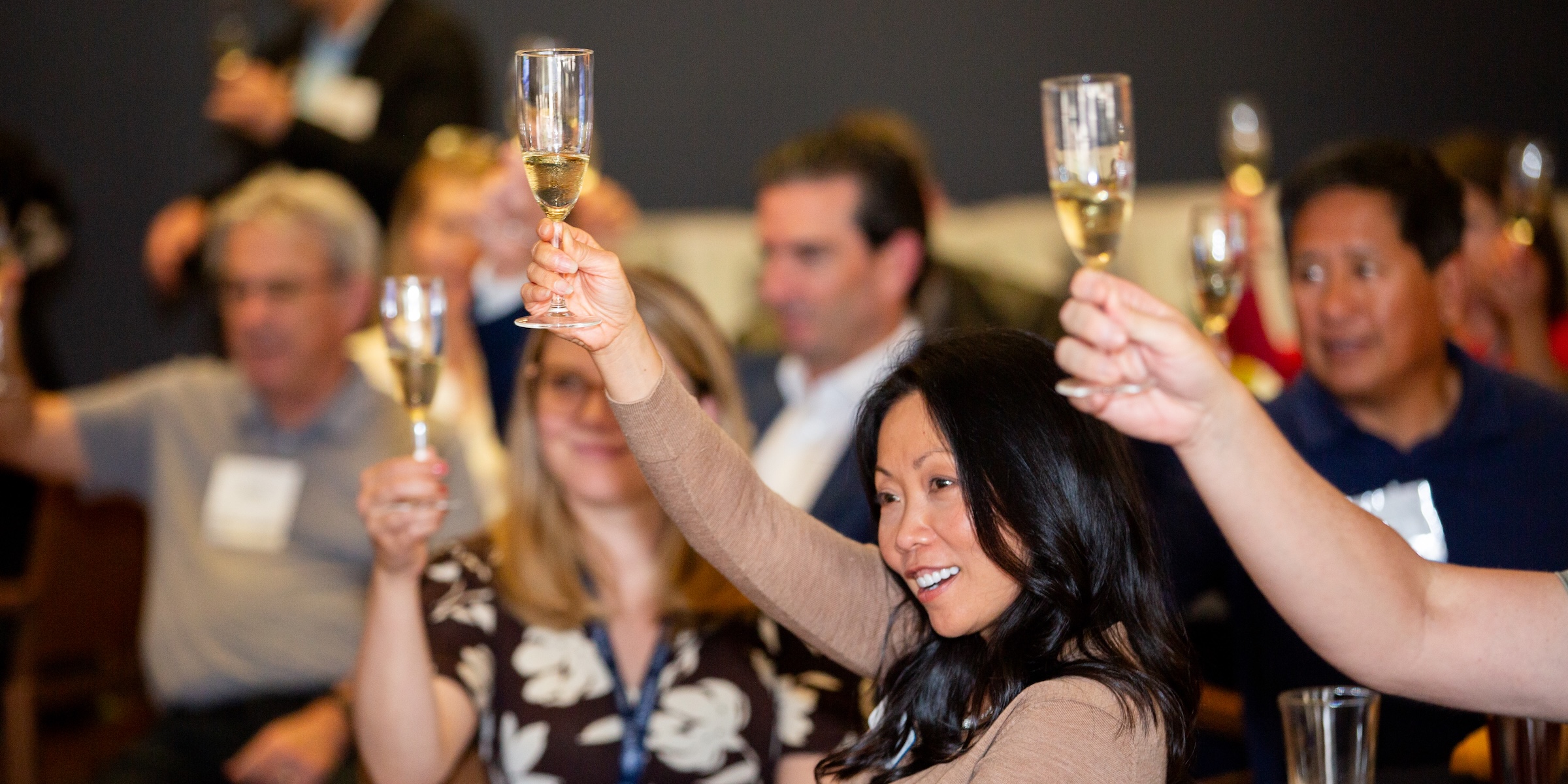 Group of people holding up glasses of champagne