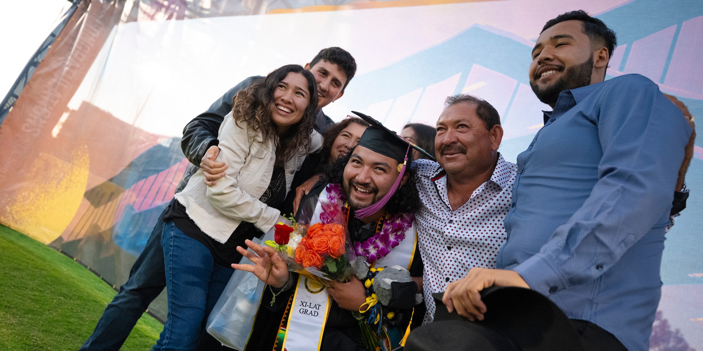 A graduate smiling with his family