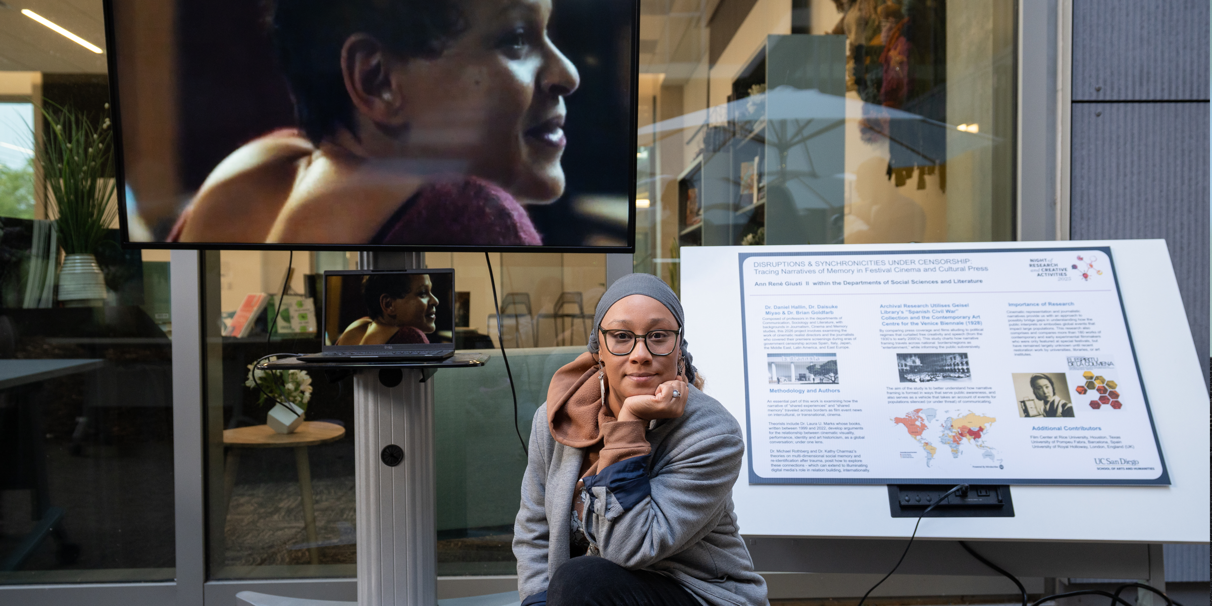 A student sits in front of their research display