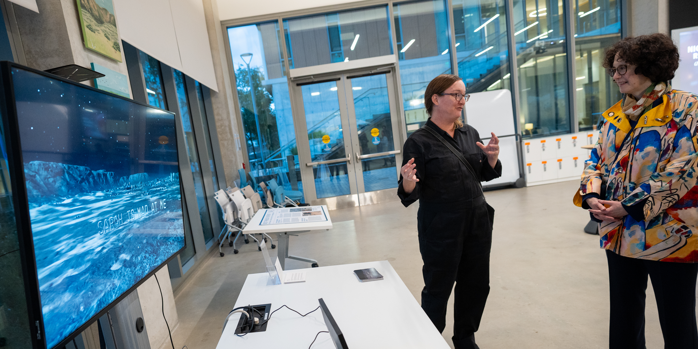 A visual arts faculty member speaks about her research display