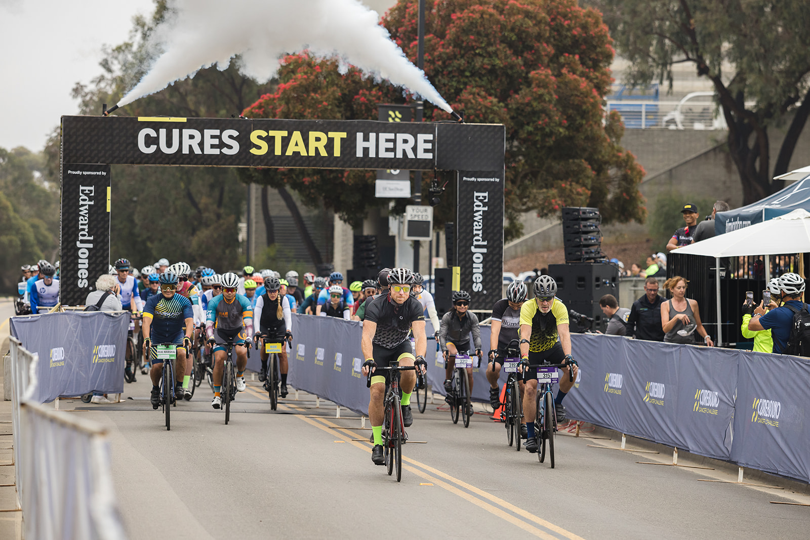 cyclists riding between fences