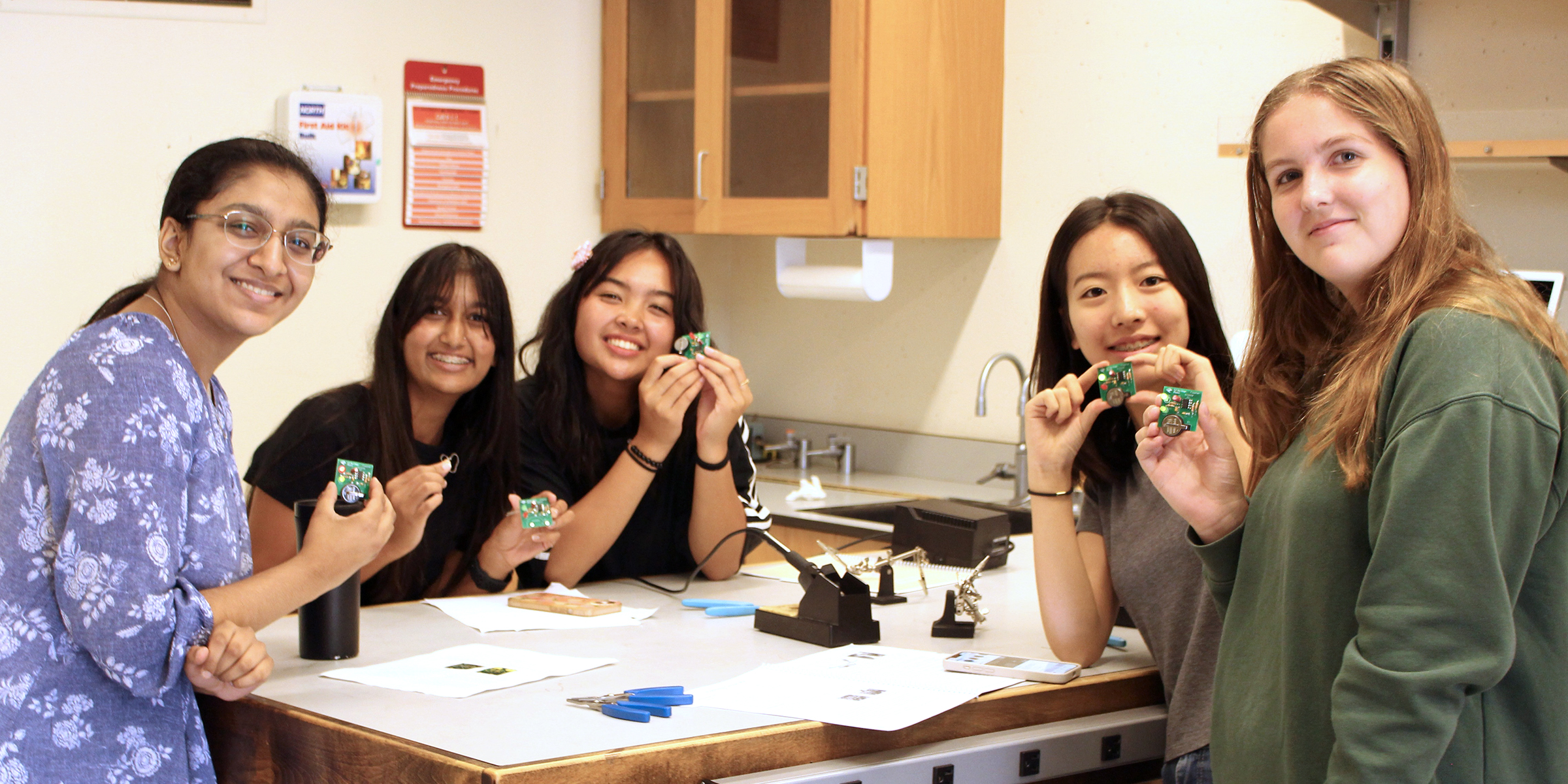 students hold up printed circuit boards