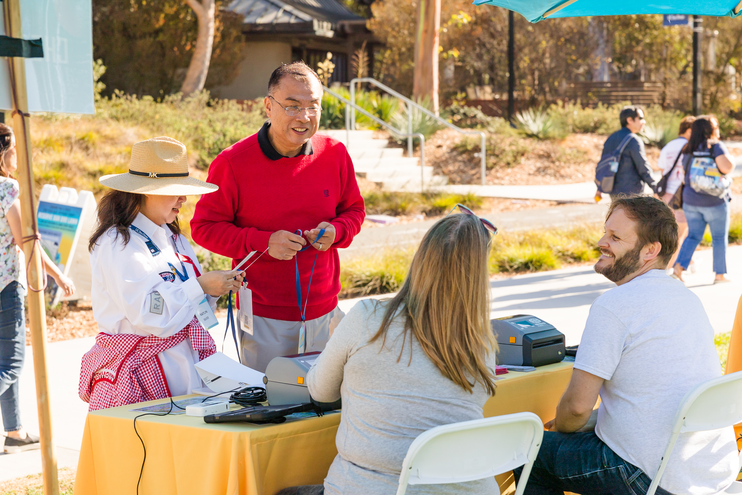 Two people check in at a table while volunteers smile.