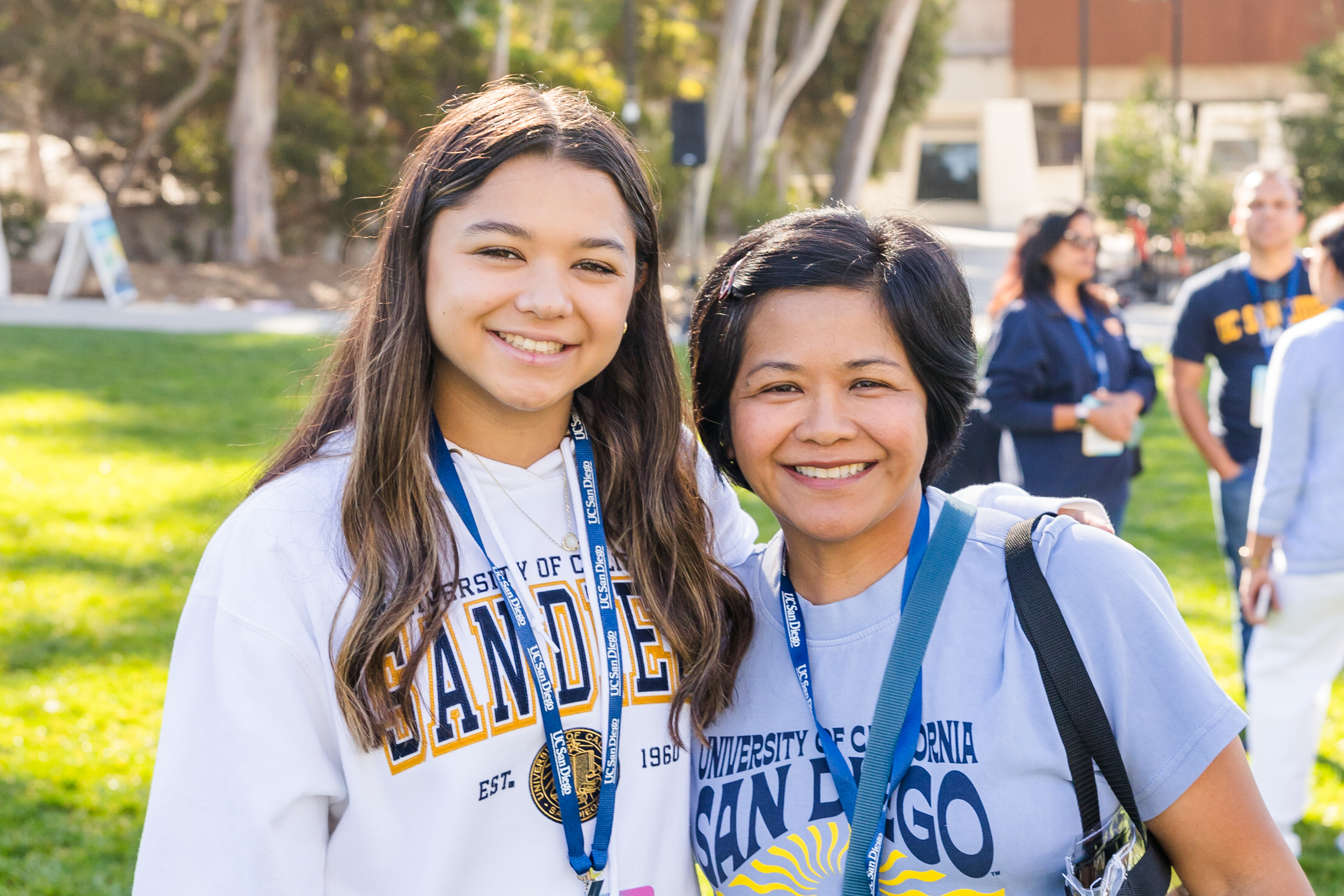 Two people wearing UC San Diego-branded gear smile at the camera.