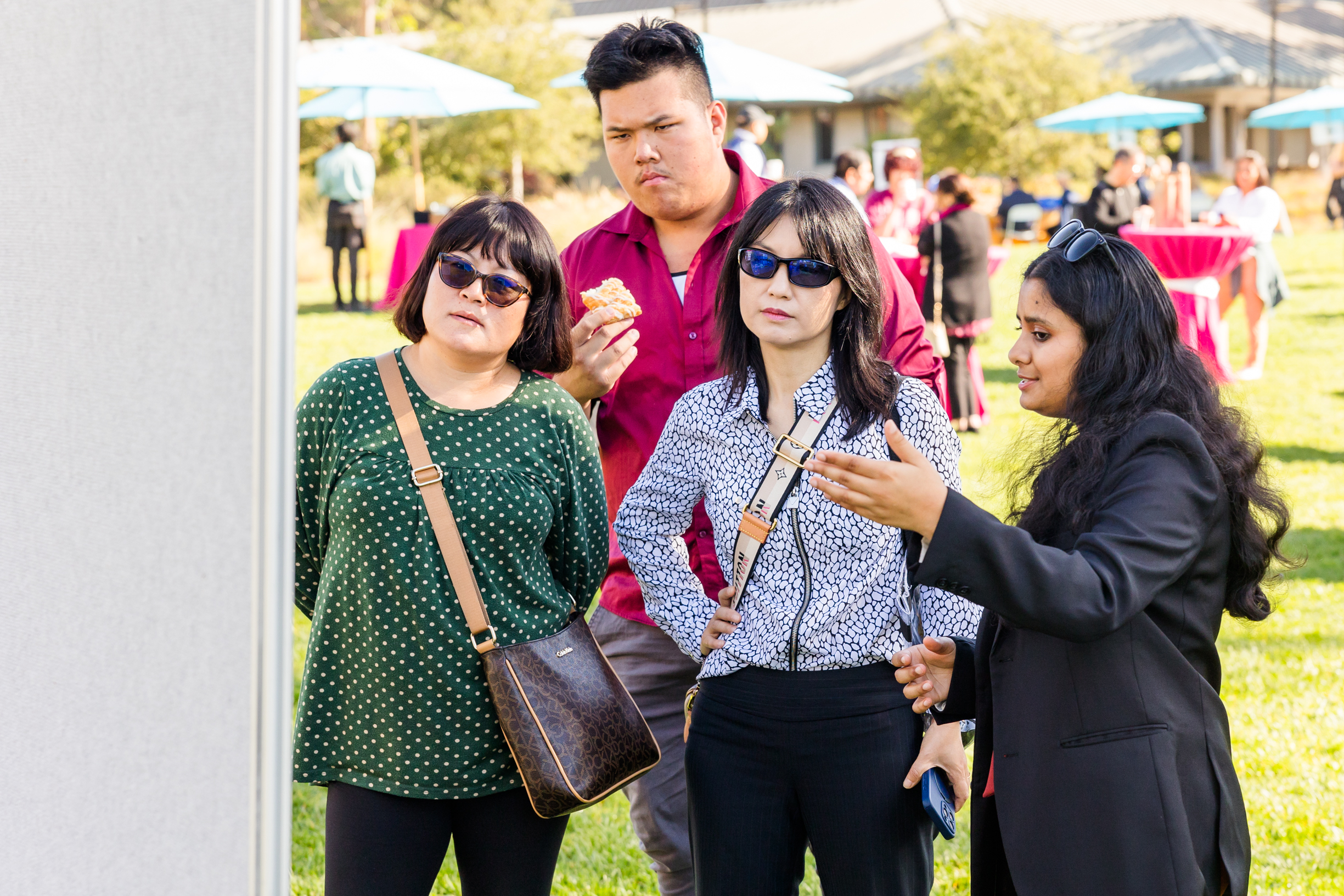 A student talks about their research to a small group. 