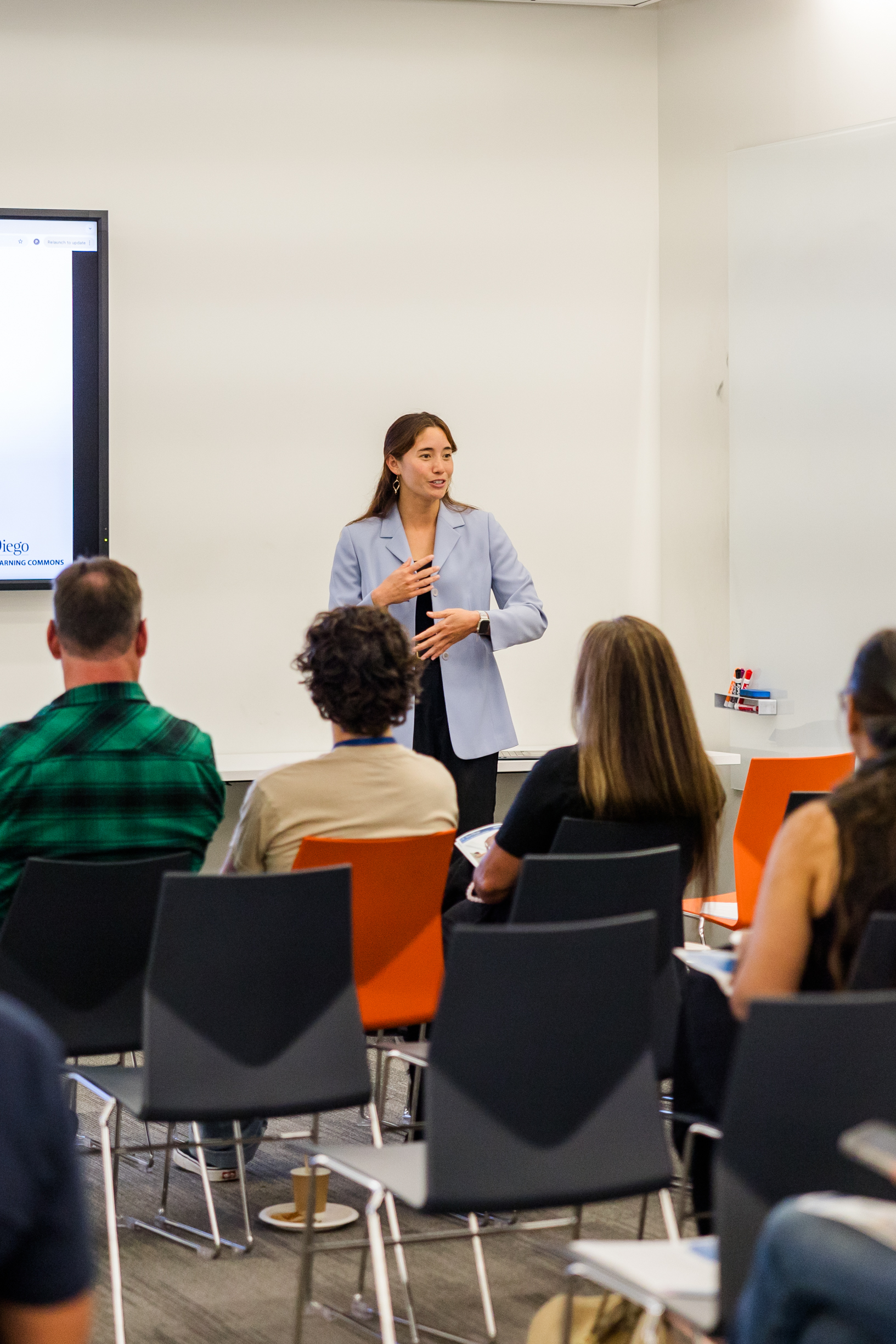 A presenter speaks to a group.