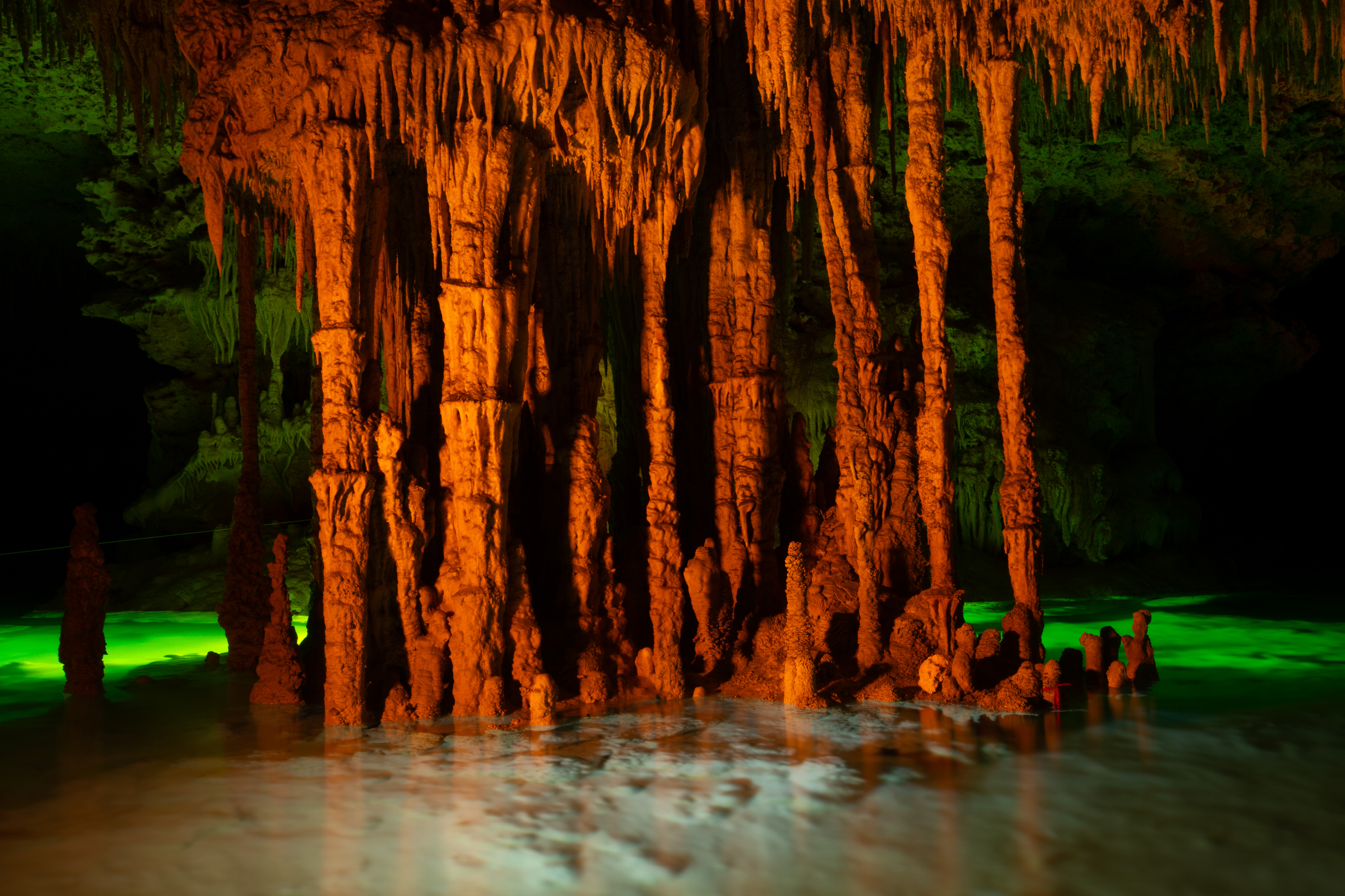 Photo showing cave formations lit in orange. Photo by Fabio Esteban Amador.
