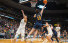 Slideshow: A basketball player wearing a blue uniform makes a reverse layup