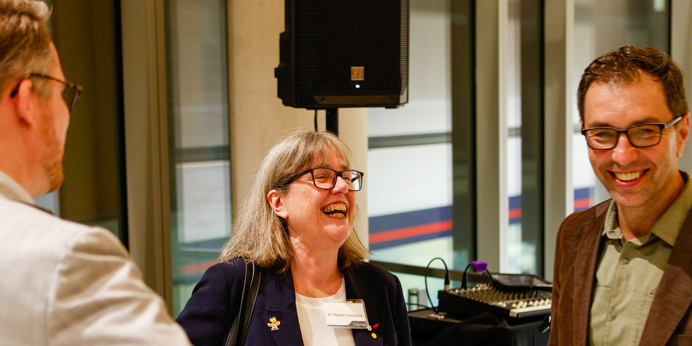 Strickland talking with others at dessert reception.