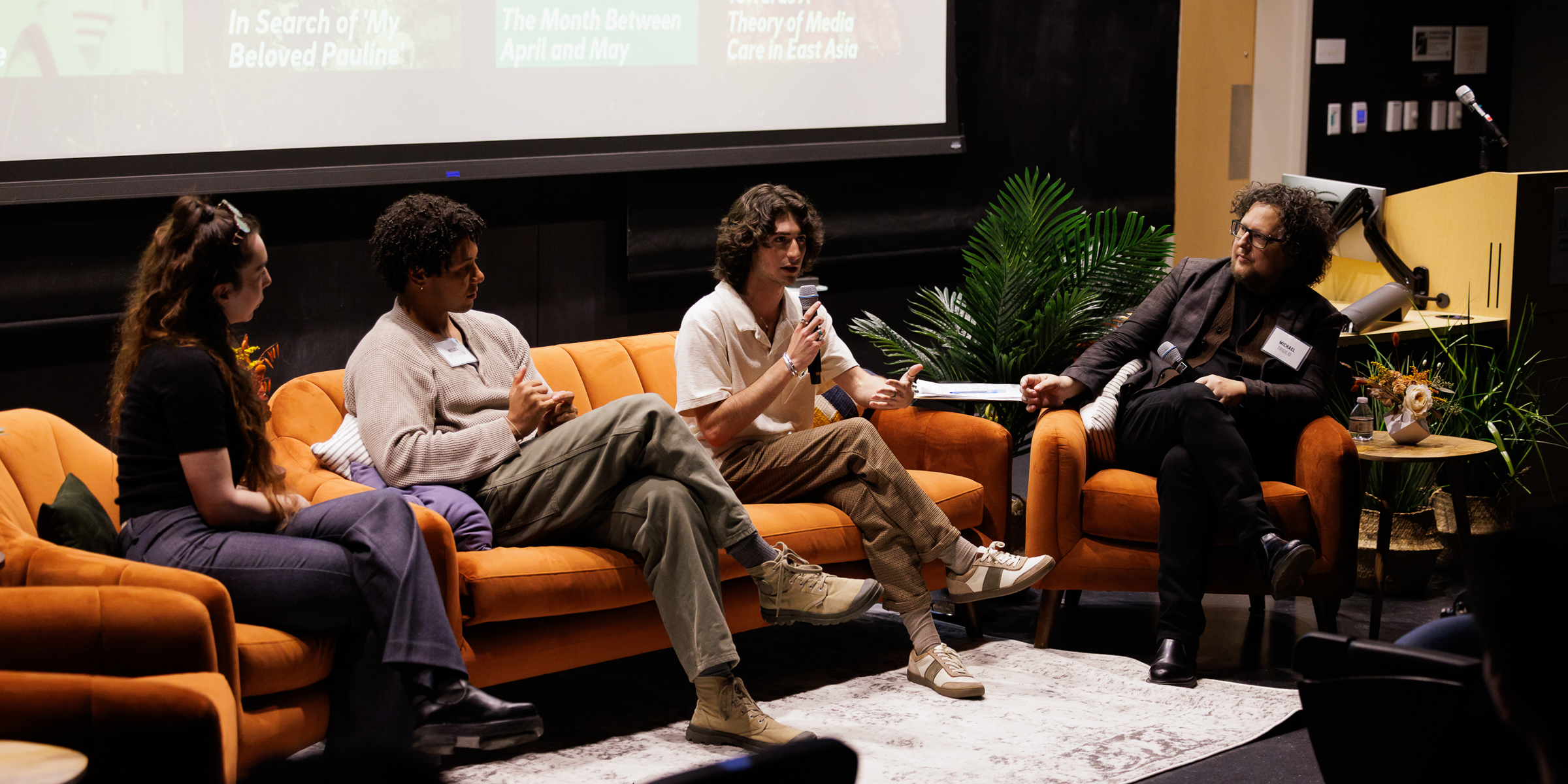A faculty moderator speaks with three fellows.
