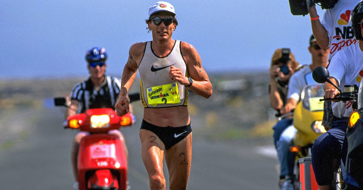 Person runs in swim suit with a motorcycle behind him