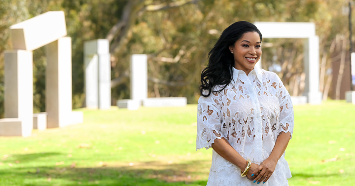 Person standing smiling in front of tall columns