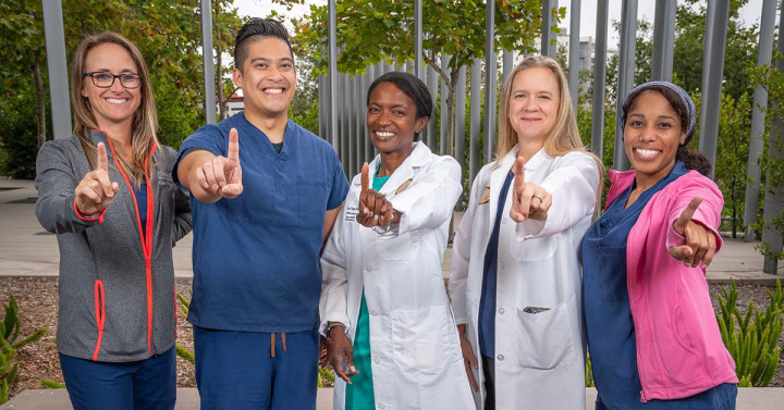 Five clinicians hold up fingers signifying No. 1 ranking